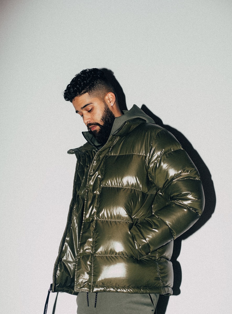 AP Dhillon South Asian man in a puffer jacket posing.