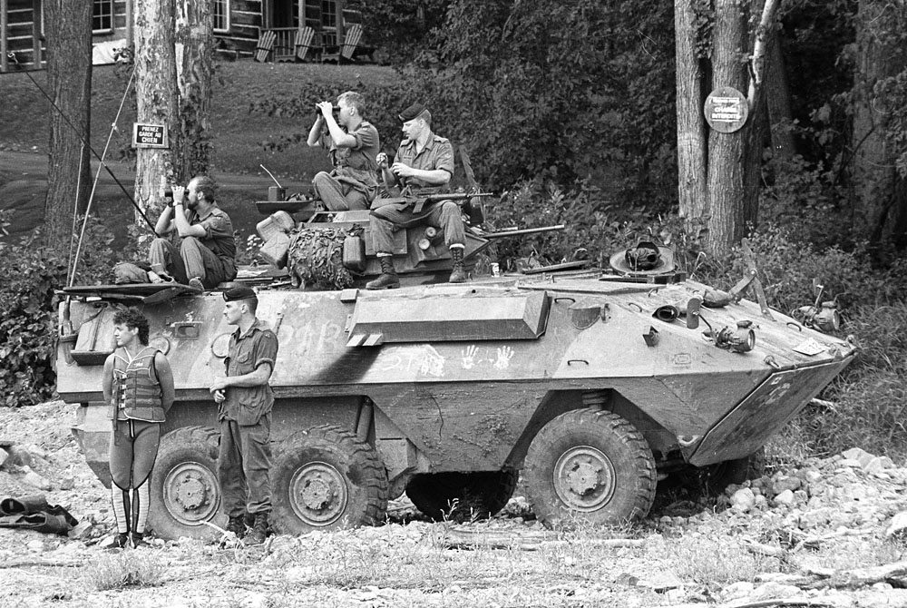 Grizzly AVGP, Kanesetake 1990 A Grizzly APC with a few soldiers around in front of some trees and a house in the background