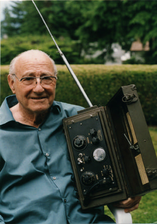 Portrait of Donald Lewes Hings holding a model of the walkie-talkie.