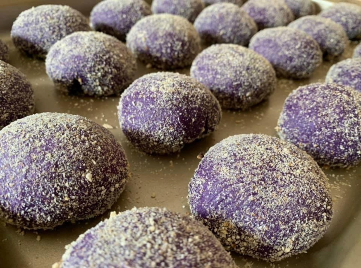 Rows of purple-coloured buns on a tray.