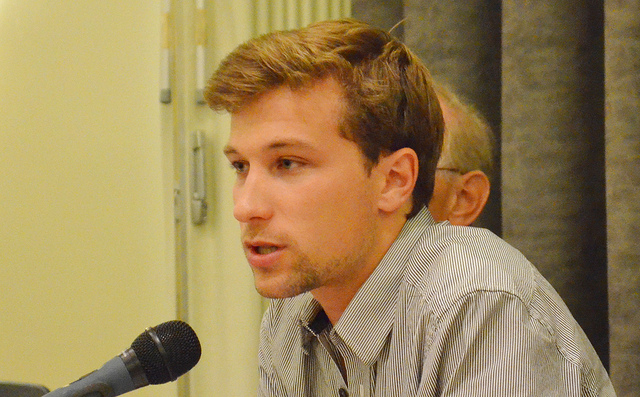 A man speaking with a microphone.