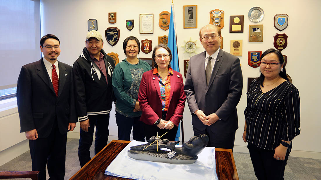 Six people stand together in an office at the United Nations International Maritime Organization