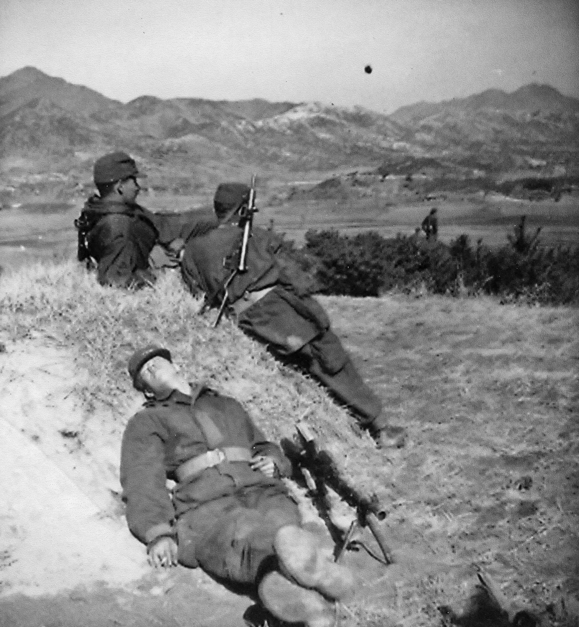 À l'avant-plan, M. Martel prenant un moment de repos avec son fusil-mitrailleur Bren non loin, sur la colline 123 (printemps 1953).