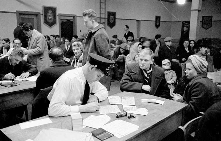 Examination Hall, Pier 21 Black and white photo of immigrants and officials.