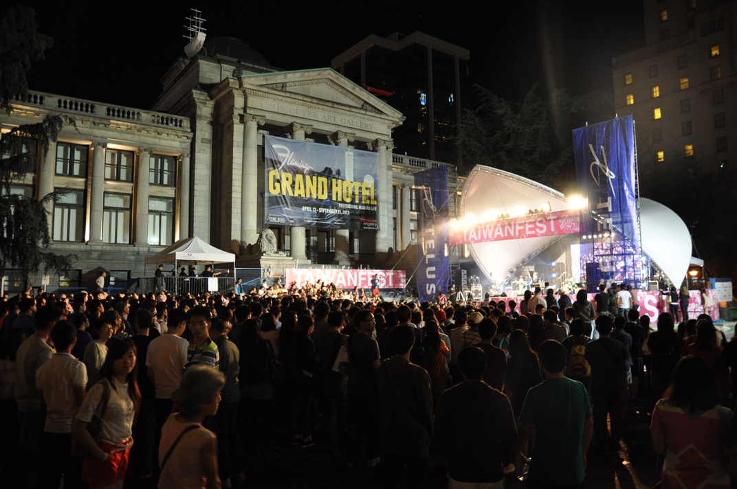 A crowd in front of a concert stage and the Vancouver Art Gallery