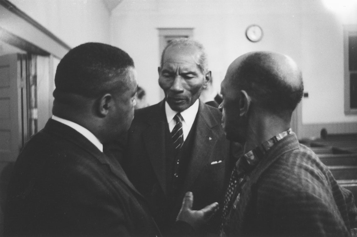 B.A. Husbands at a Public Meeting