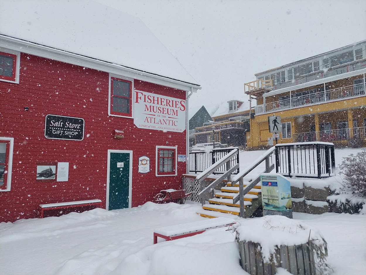 Fisheries Museum of the Atlantic Red building surrounded by falling snow.