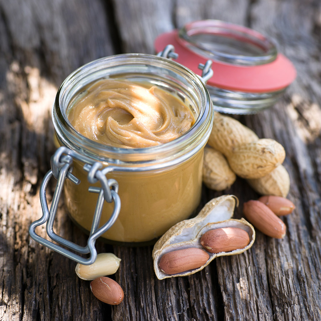 A jar of peanut butter and peanuts, date unknown.