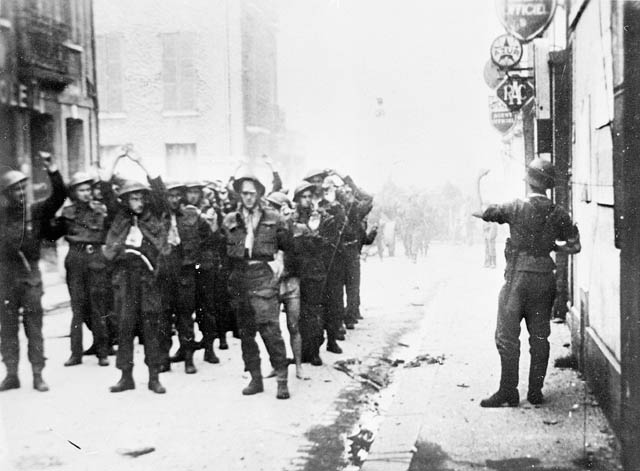 German soldiers lead Canadian prisoners of war through the streets of Dieppe following the disastrous raid on the French port on 19 August, 1942.