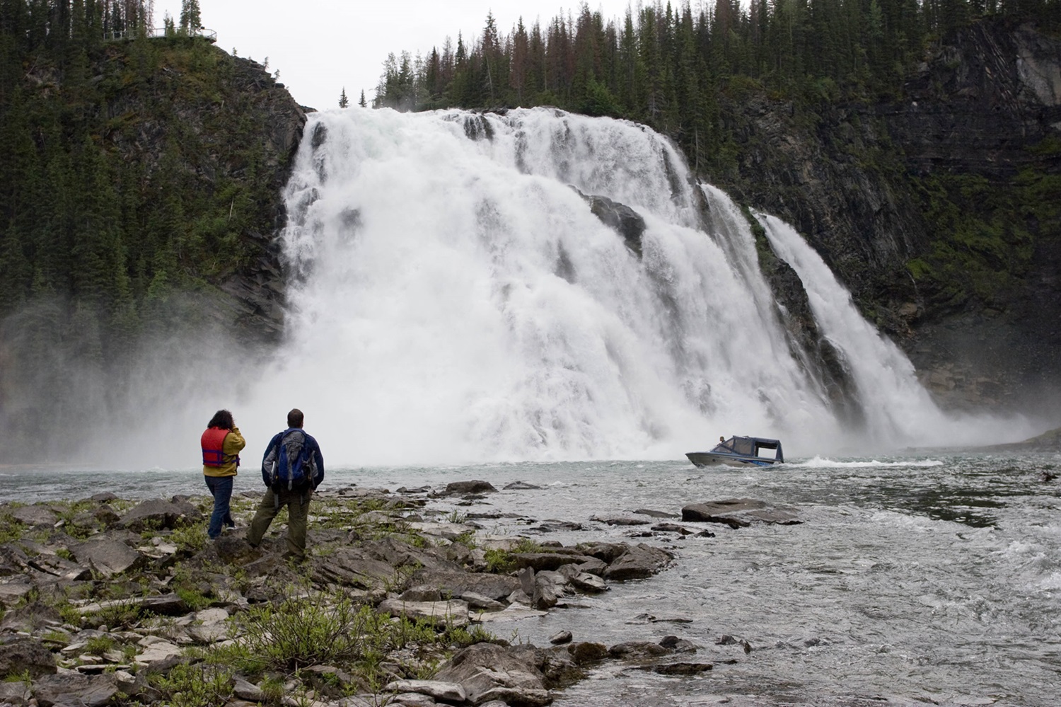 Waterfall, with two hikers in the foreground.