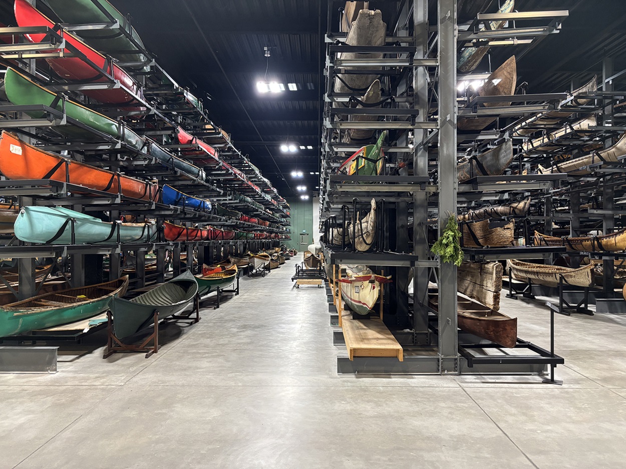 Canadian Canoe Museum Collection Hall Rows and rows of canoes in a warehouse-like chamber.