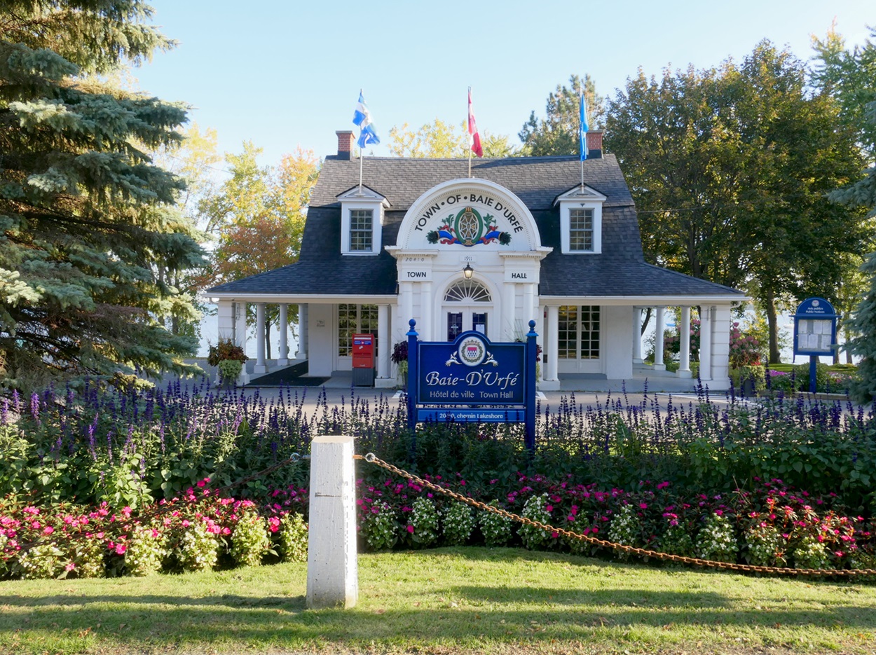 Baie-D'Urfé Town Hall White building with a sign reading “Baie-D'Urfé.”